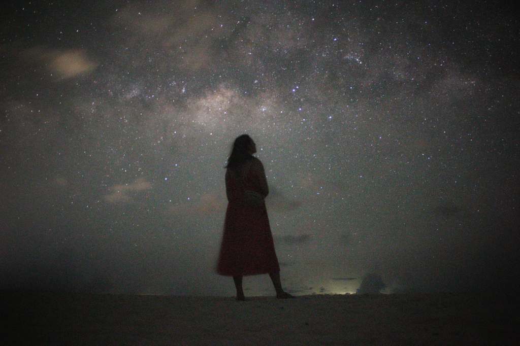 a long exposure photo of libby admiring the night sky over fulhadhoo